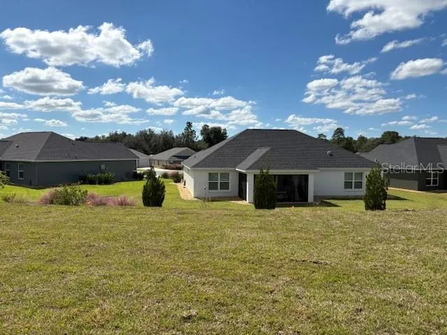 a yellow house with a big yard and large tree