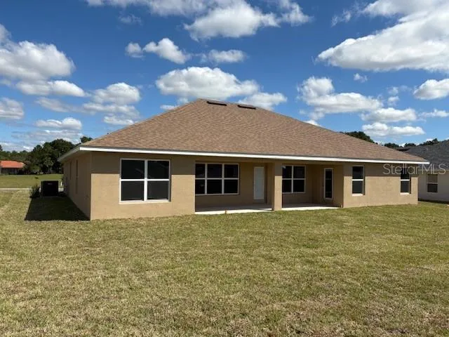a house that has a big yard large trees with wooden fence