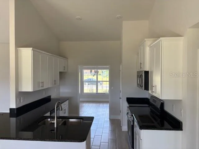 a kitchen with granite countertop a sink cabinets and window