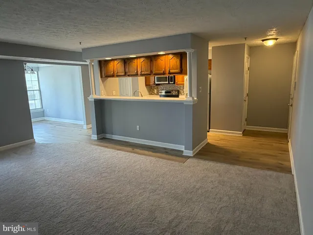an empty room with windows fire place and flat screen tv