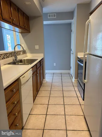a kitchen with a sink a stove and a refrigerator