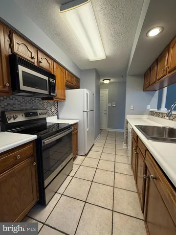 a kitchen with a sink a stove and cabinets
