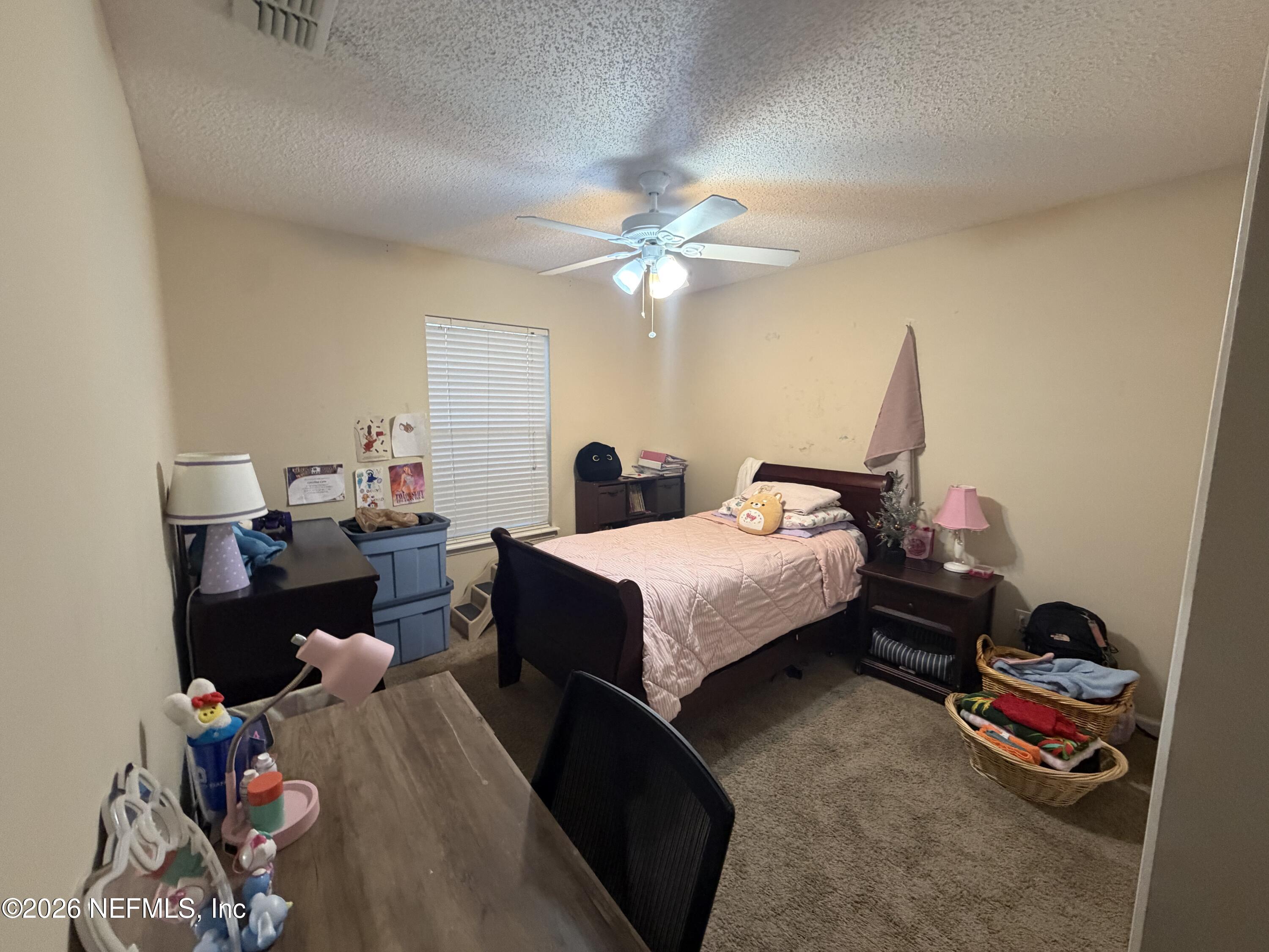 1478 Winston Lane Fleming Island, FL 32003 - Photo 11 of 15 a bedroom with a bed and a chandelier