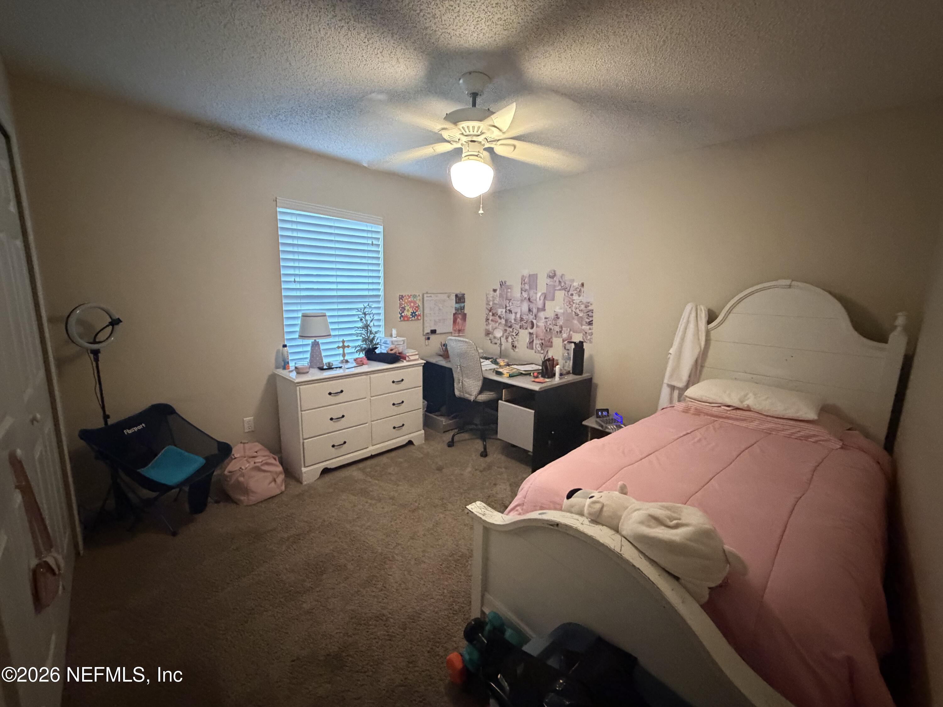 1478 Winston Lane Fleming Island, FL 32003 - Photo 12 of 15 a bedroom with a bed and a chandelier