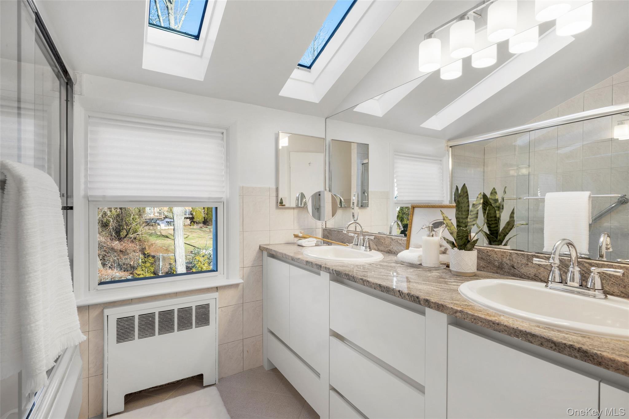 151 Hilburn Road Scarsdale, NY 10583 - Photo 28 of 40 a bathroom with a double vanity sink and a window