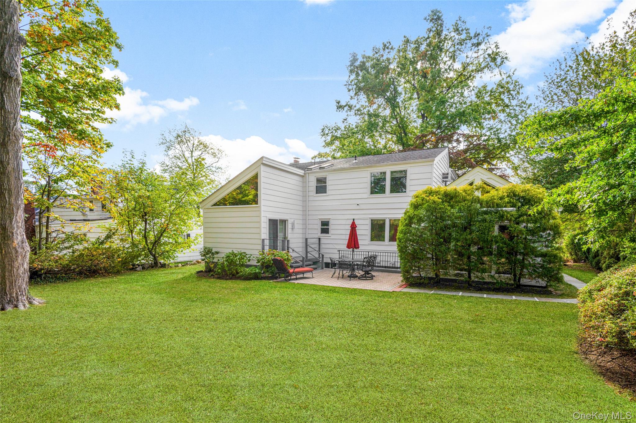151 Hilburn Road Scarsdale, NY 10583 - Photo 32 of 40 a house view with a sitting space and garden