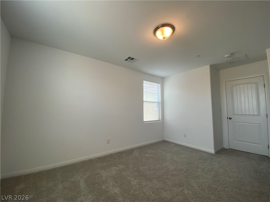 436 Cadence View Way Henderson, NV 89011 - Photo 9 of 36 A well-lit bedroom features plush carpeting and a bright window.