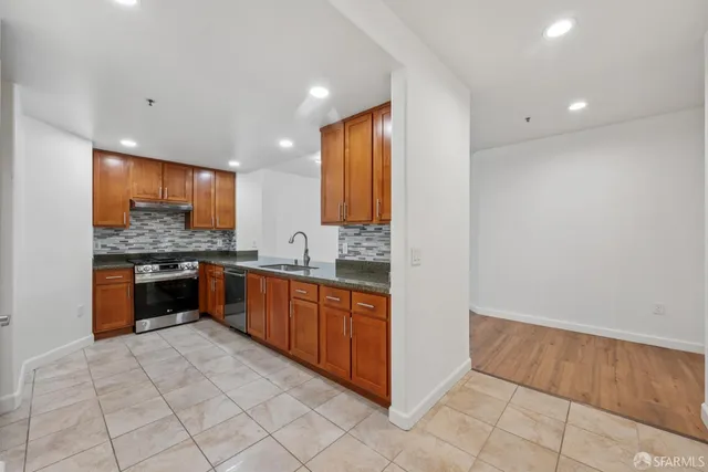 a large kitchen with stainless steel appliances a large counter top and a stove