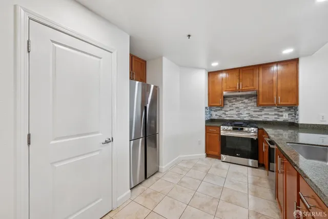 a kitchen with stainless steel appliances granite countertop a refrigerator and a sink