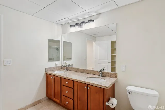 a bathroom with a granite countertop sink a toilet and a mirror