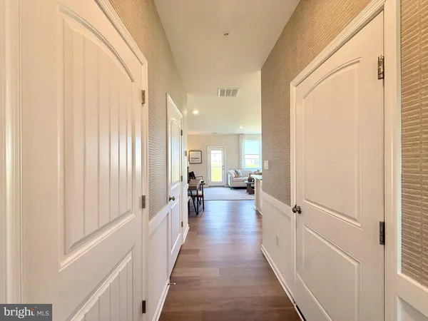 a view of a hallway with wooden floor and furniture
