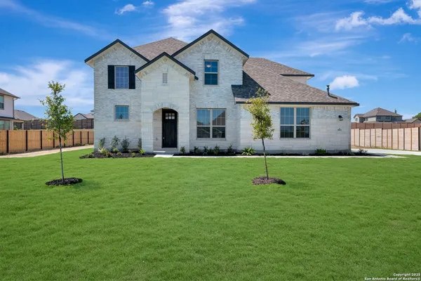 a front view of a house with a yard and green space