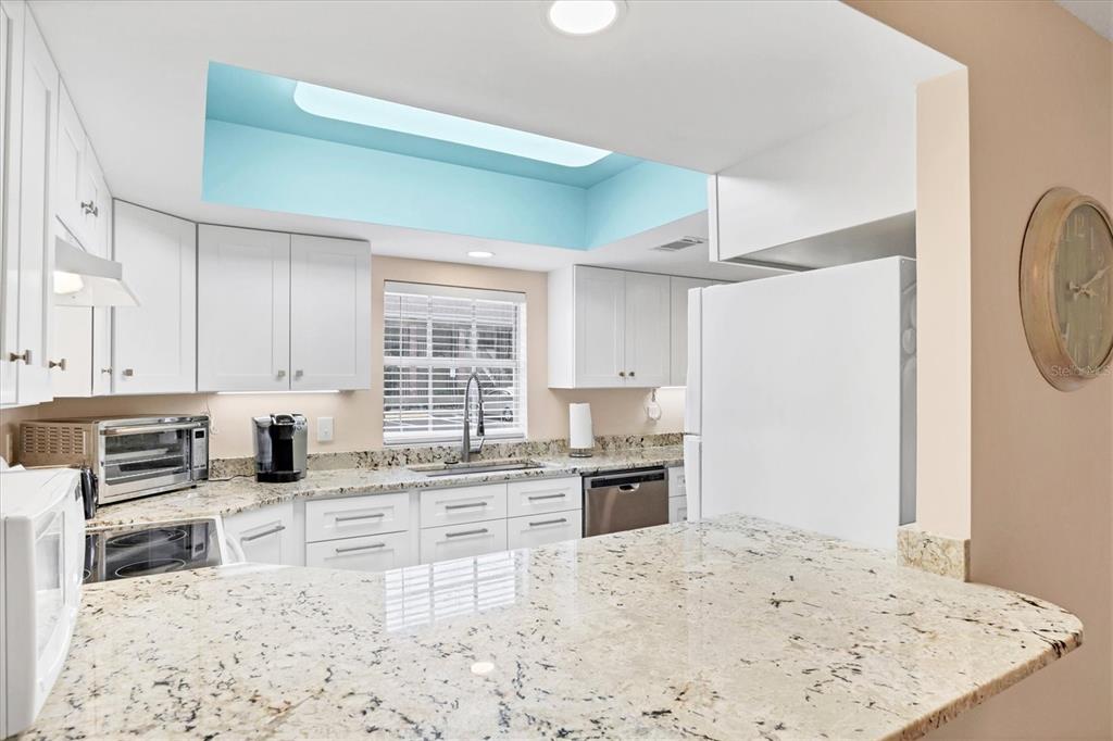 1531 Placida Road, Unit 4102 Englewood, FL 34223 - Photo 16 of 55 a kitchen with stainless steel appliances kitchen island granite countertop a refrigerator and a stove top oven
