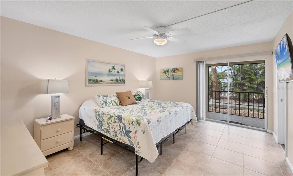 1531 Placida Road, Unit 4102 Englewood, FL 34223 - Photo 23 of 55 a bed room with a bed and a night stand