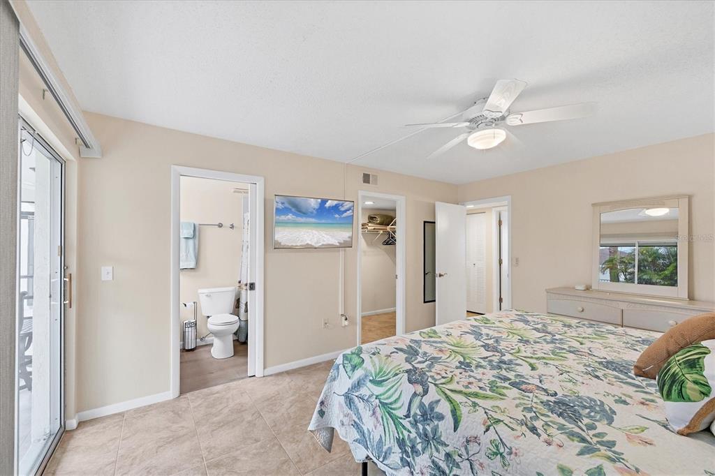 1531 Placida Road, Unit 4102 Englewood, FL 34223 - Photo 26 of 55 a bedroom with a bed and a chandelier