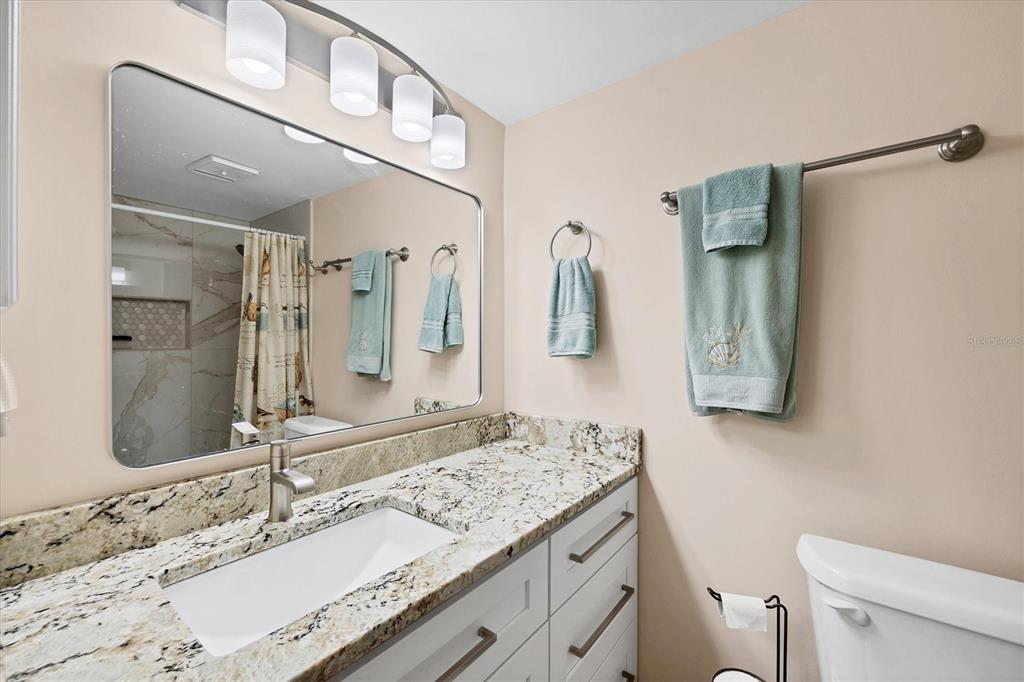 1531 Placida Road, Unit 4102 Englewood, FL 34223 - Photo 27 of 55 a bathroom with a granite countertop sink a mirror and a toilet