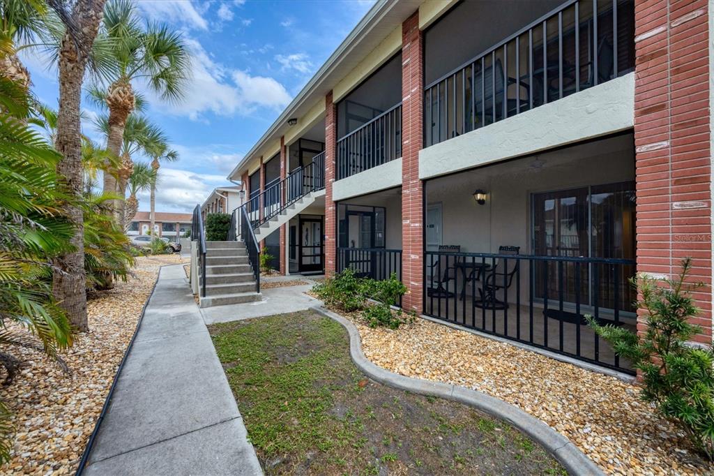 1531 Placida Road, Unit 4102 Englewood, FL 34223 - Photo 4 of 55 a view of a brick house with a small yard plants and large tree