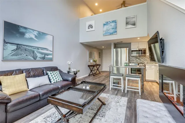 a living room with furniture a flat screen tv and kitchen view