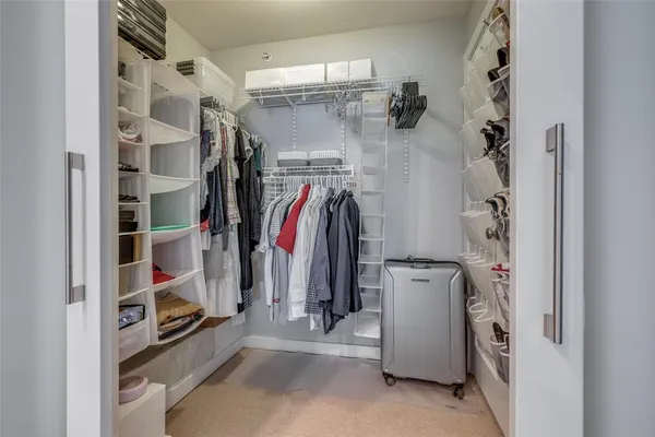 a view of walk in closet with clothes and shoes