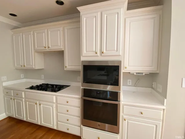 a kitchen with white cabinets and black appliances
