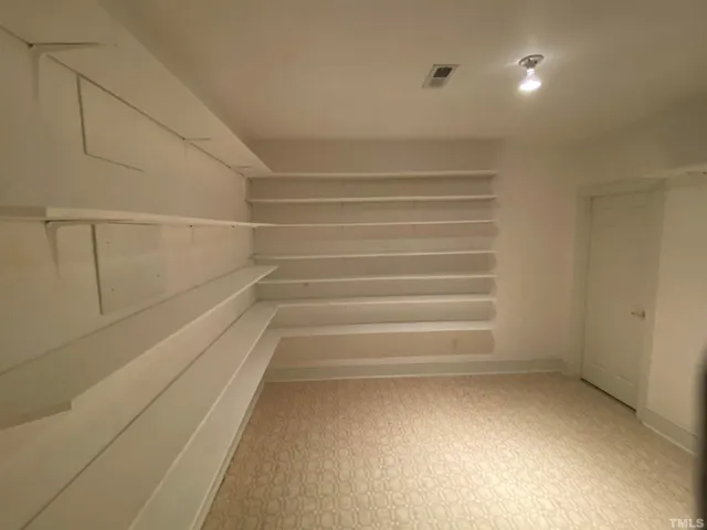 a view of walk in closet with empty racks