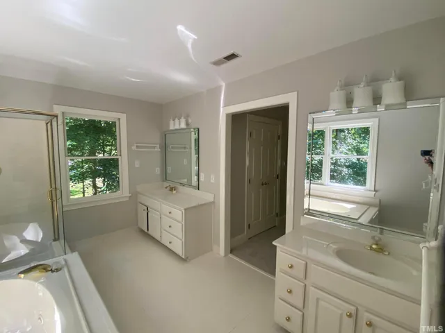 a bathroom with a tub sink a mirror and a bathtub