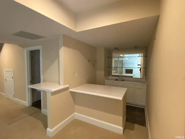 a room with a sink a stove and a mirror