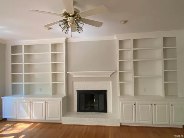 a living room with a fireplace cabinet and a large window