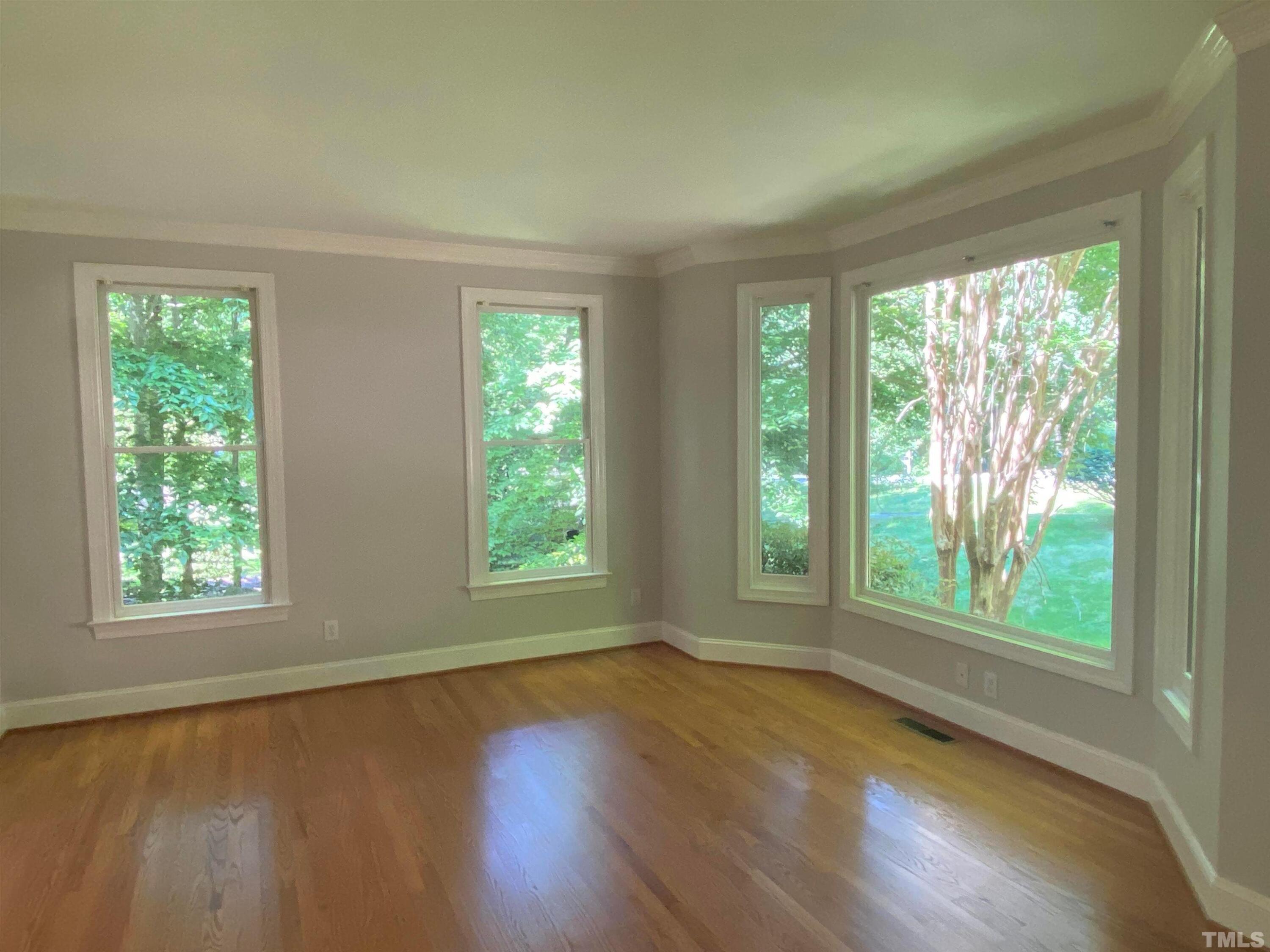 10621 Cahill Road Raleigh, NC 27614 - Photo 9 of 32 a view of an empty room with wooden floor and a window