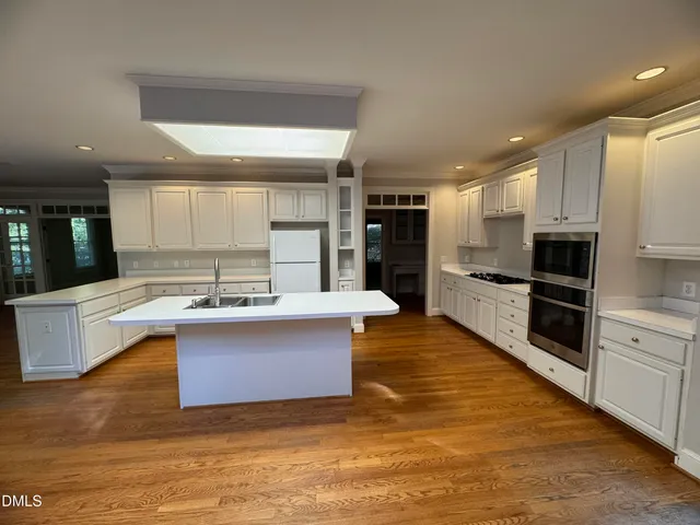 a large kitchen with stainless steel appliances kitchen island granite countertop a large counter top and a stove