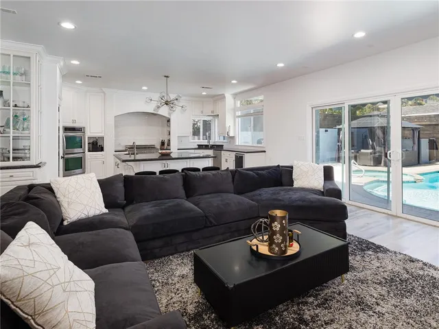 a living room with furniture kitchen and a chandelier