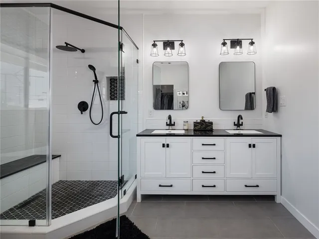 a bathroom with double vanity and a shower