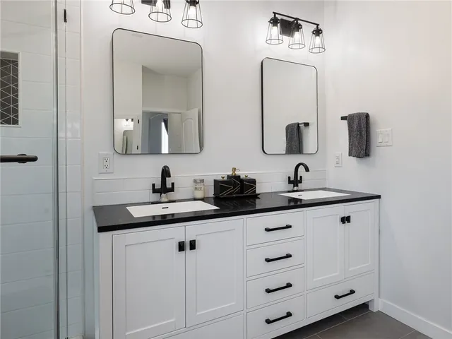 a bathroom with a double vanity sink and mirror