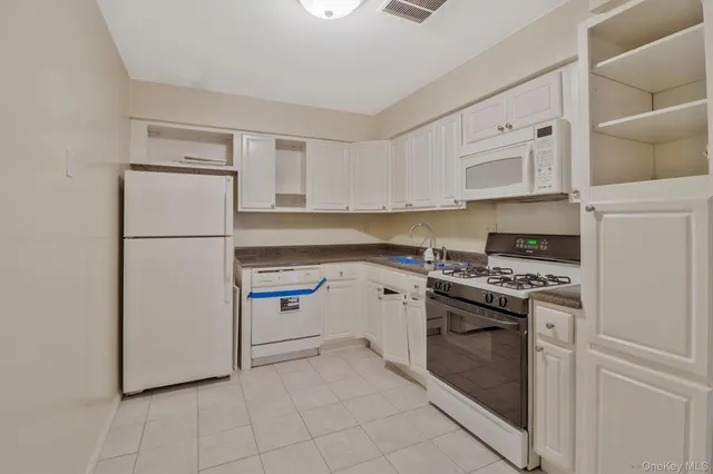 a kitchen with cabinets stainless steel appliances and a counter space