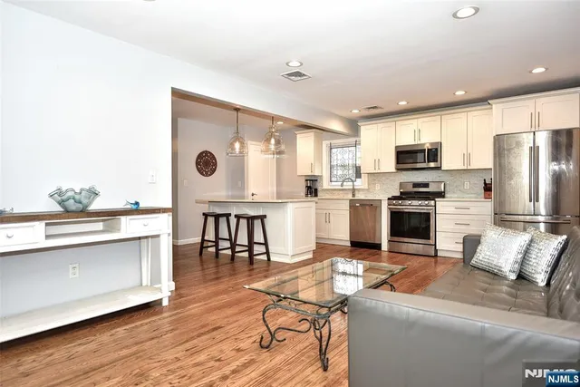 a living room with stainless steel appliances kitchen island granite countertop furniture and a kitchen view