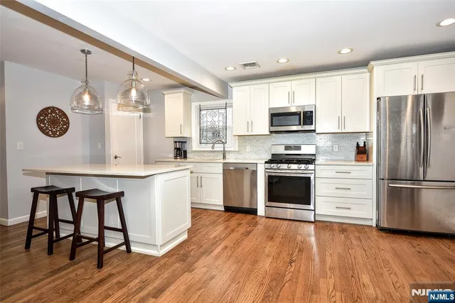 a kitchen with a refrigerator stove and white cabinets