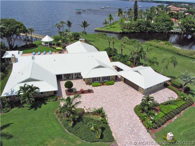 Exterior Front. Private Tropical Retreat on the St. Lucie River. Enjoy one acre of Tropical landscaping, new paver drivewayand detached garage on a private street.