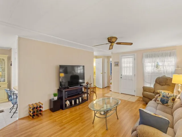a living room with furniture and a flat screen tv with wooden floor