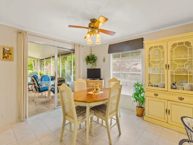 a dining room with furniture a large window and potted plants