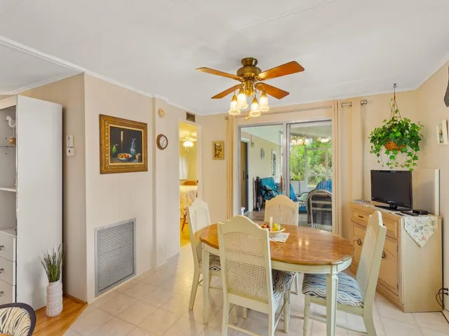a dining room with furniture a flat screen tv and a large window