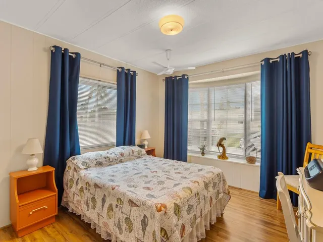 a bedroom with a bed and a dresser next to a window