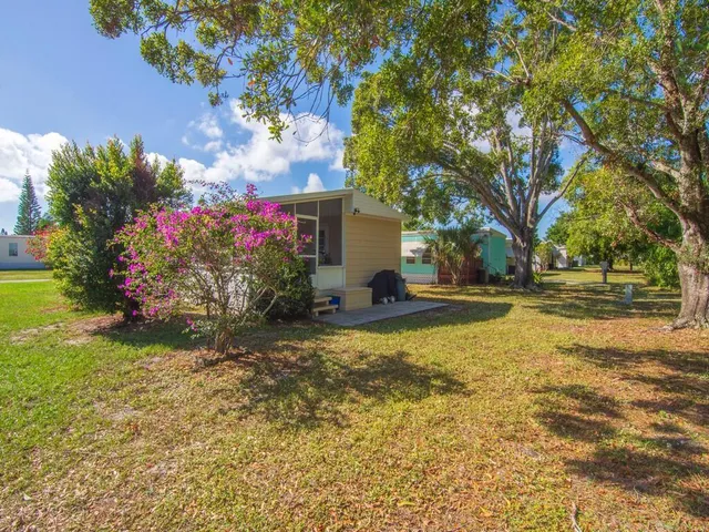 a view of a house with a yard and basketball court