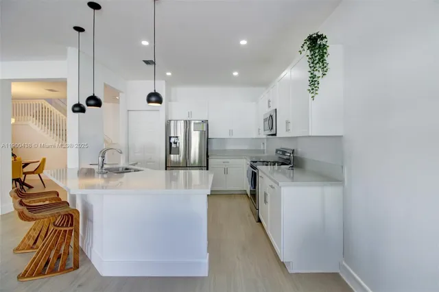 a large kitchen with kitchen island a large counter top space a sink and stainless steel appliances
