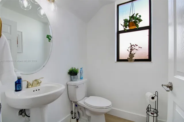 a bathroom with a sink mirror and toilet