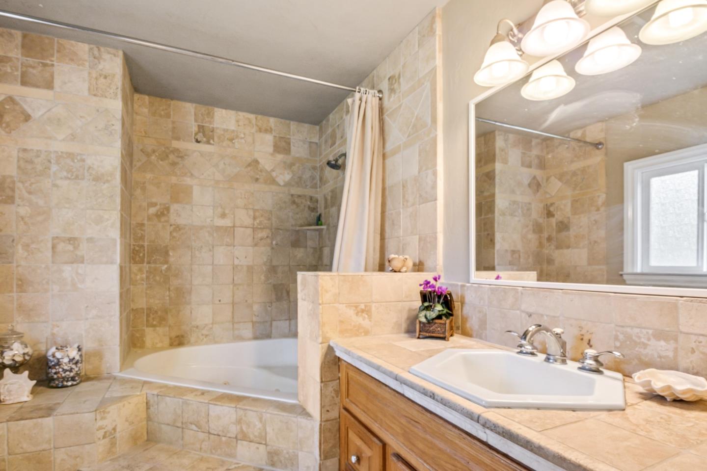 17752 Vierra Canyon Road Salinas, CA 93907 - Photo 17 of 31 a bathroom with a granite countertop sink a mirror and a bathtub