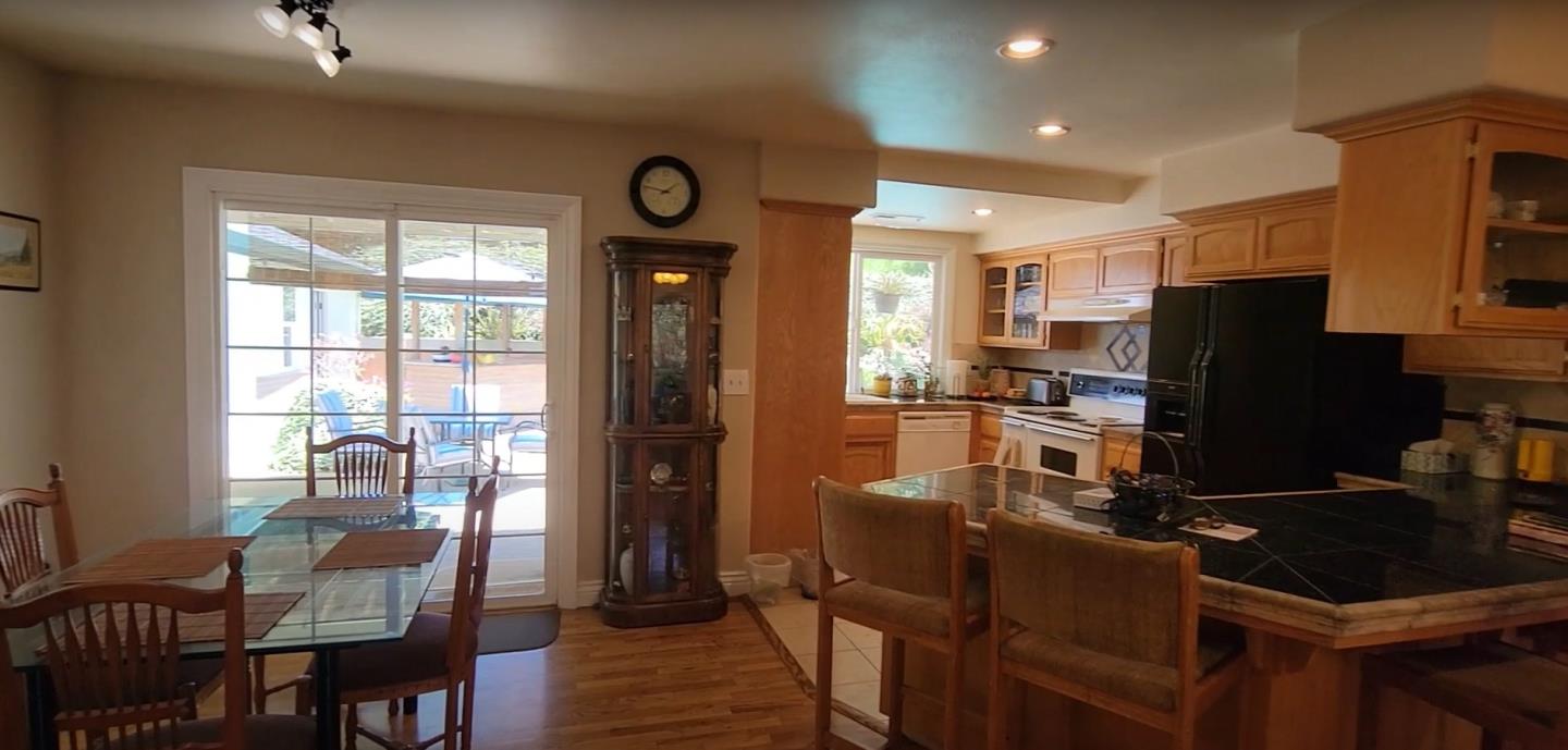 17752 Vierra Canyon Road Salinas, CA 93907 - Photo 7 of 31 a kitchen with a refrigerator a stove top oven a dining table and chairs with wooden floor