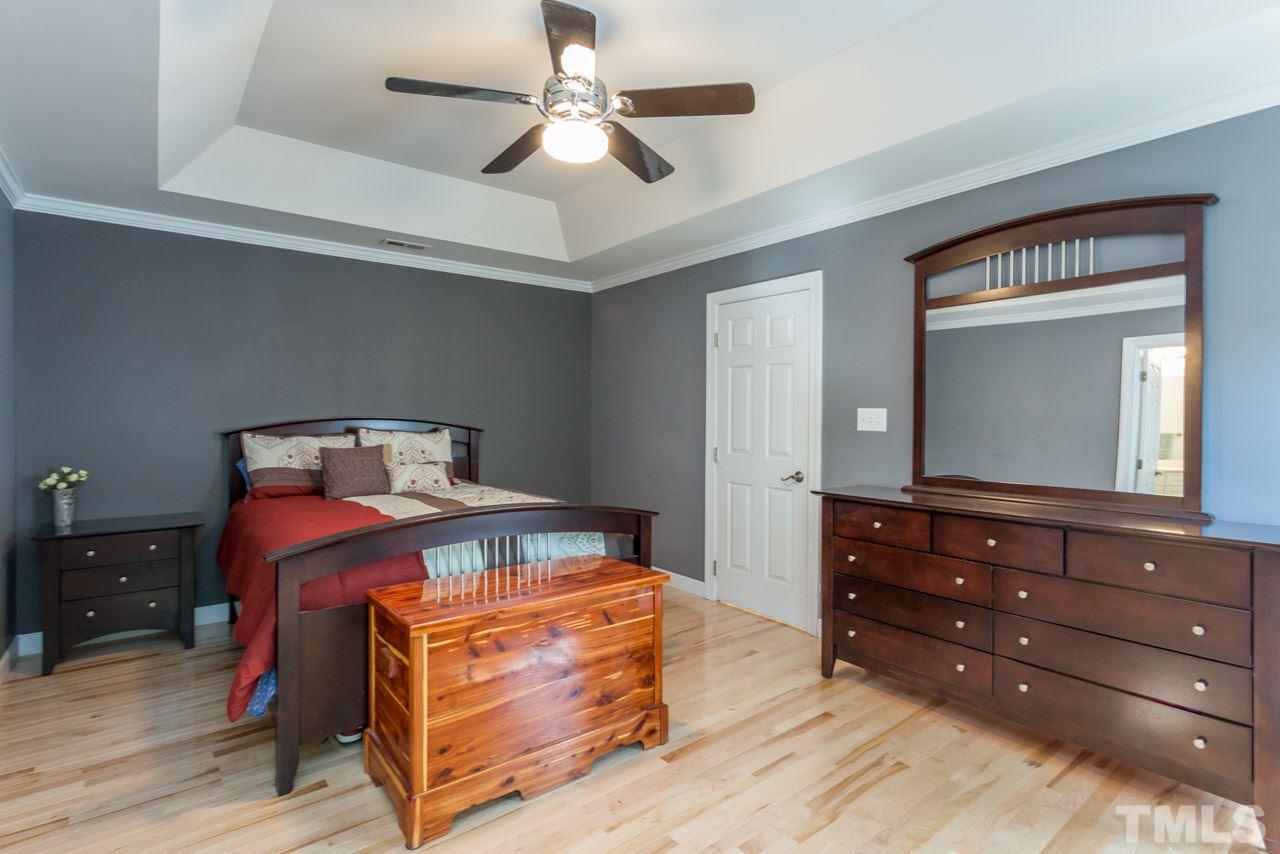 4512 Olde Stream Court Raleigh, NC 27612 - Photo 14 of 24 a bedroom with a bed and a dresser