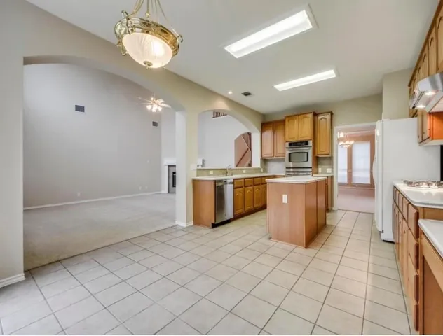 a kitchen with a sink stainless steel appliances cabinets and a counter top space