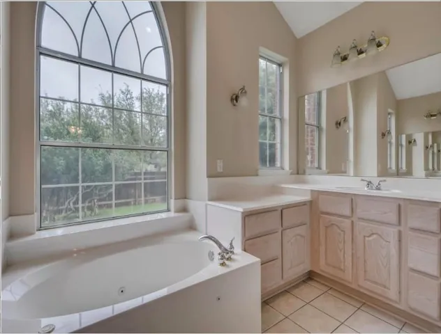 a spacious bathroom with a tub sink and mirror