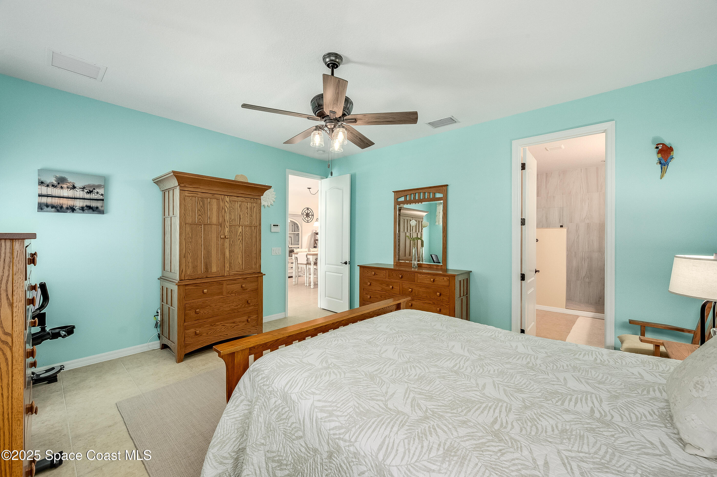 5738 Tamarac Drive Melbourne, FL 32940 - Photo 14 of 27 a bedroom with a bed and a chandelier